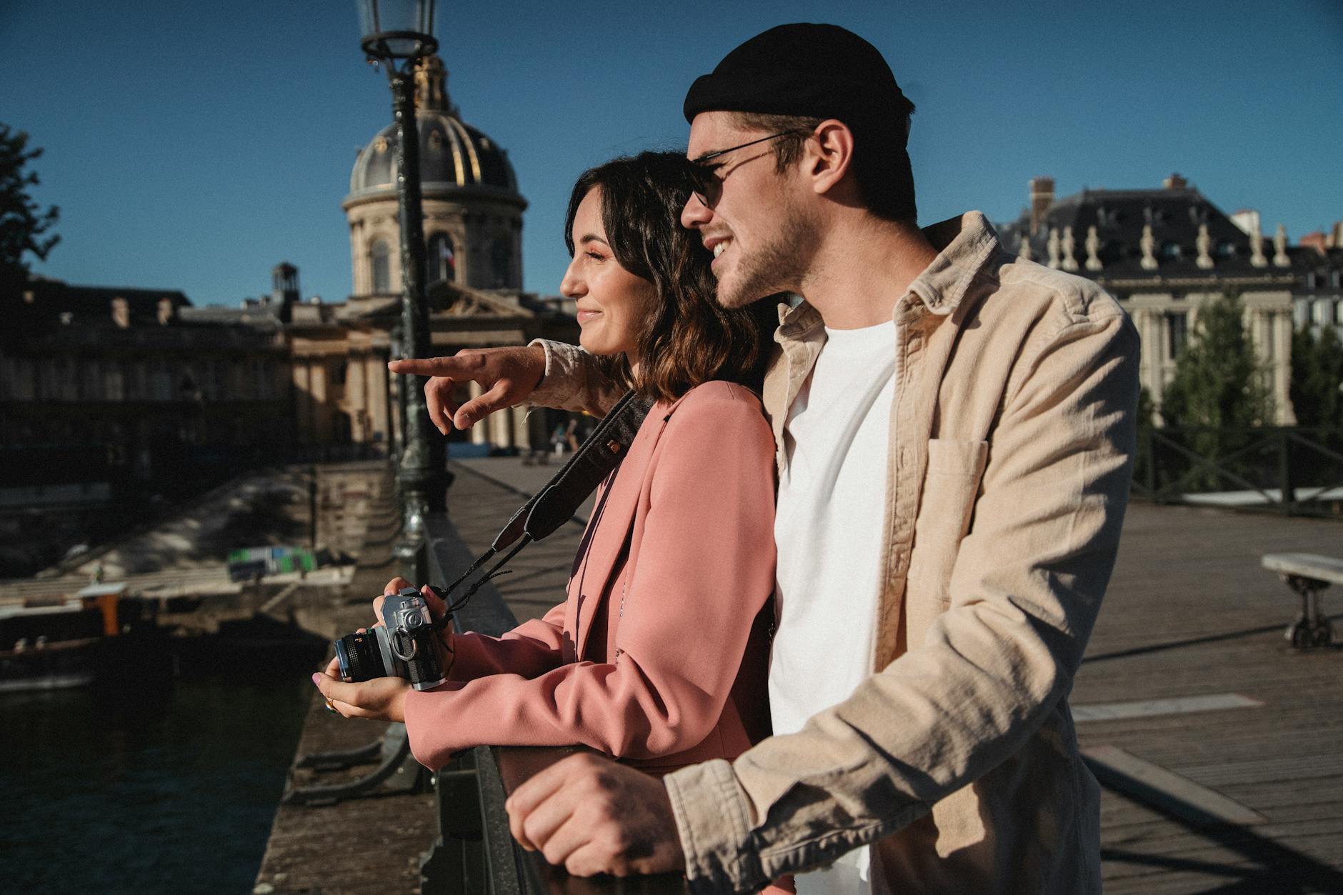 Para w modnych strojach robi zdjęcia podczas romantycznego spaceru