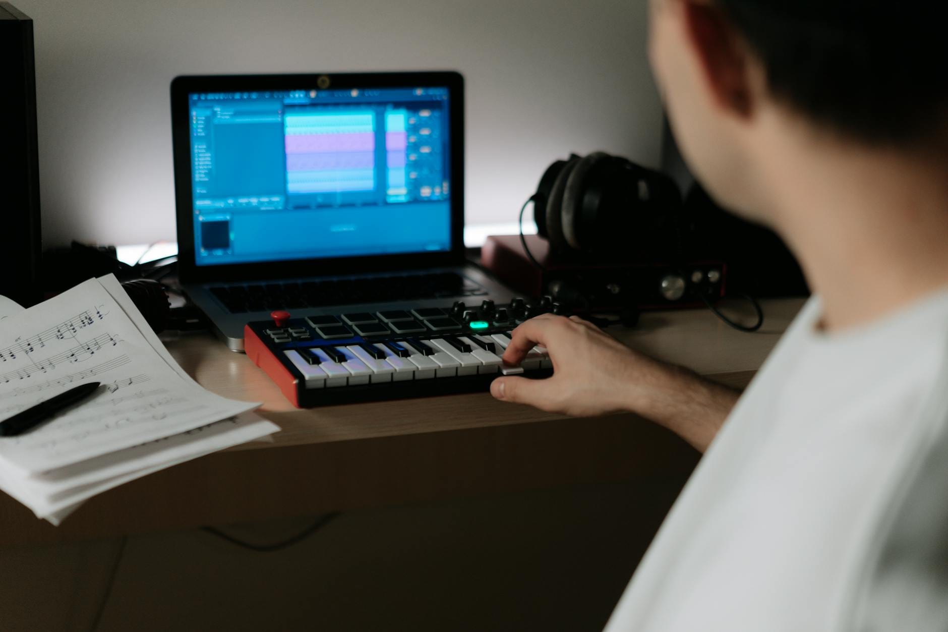 Kompozytor muzyki do gier indie przy syntezatorze w domowym studiu