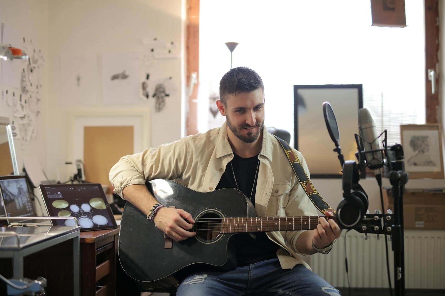 Mężczyzna gra na gitarze akustycznej w domowym studiu relaksu