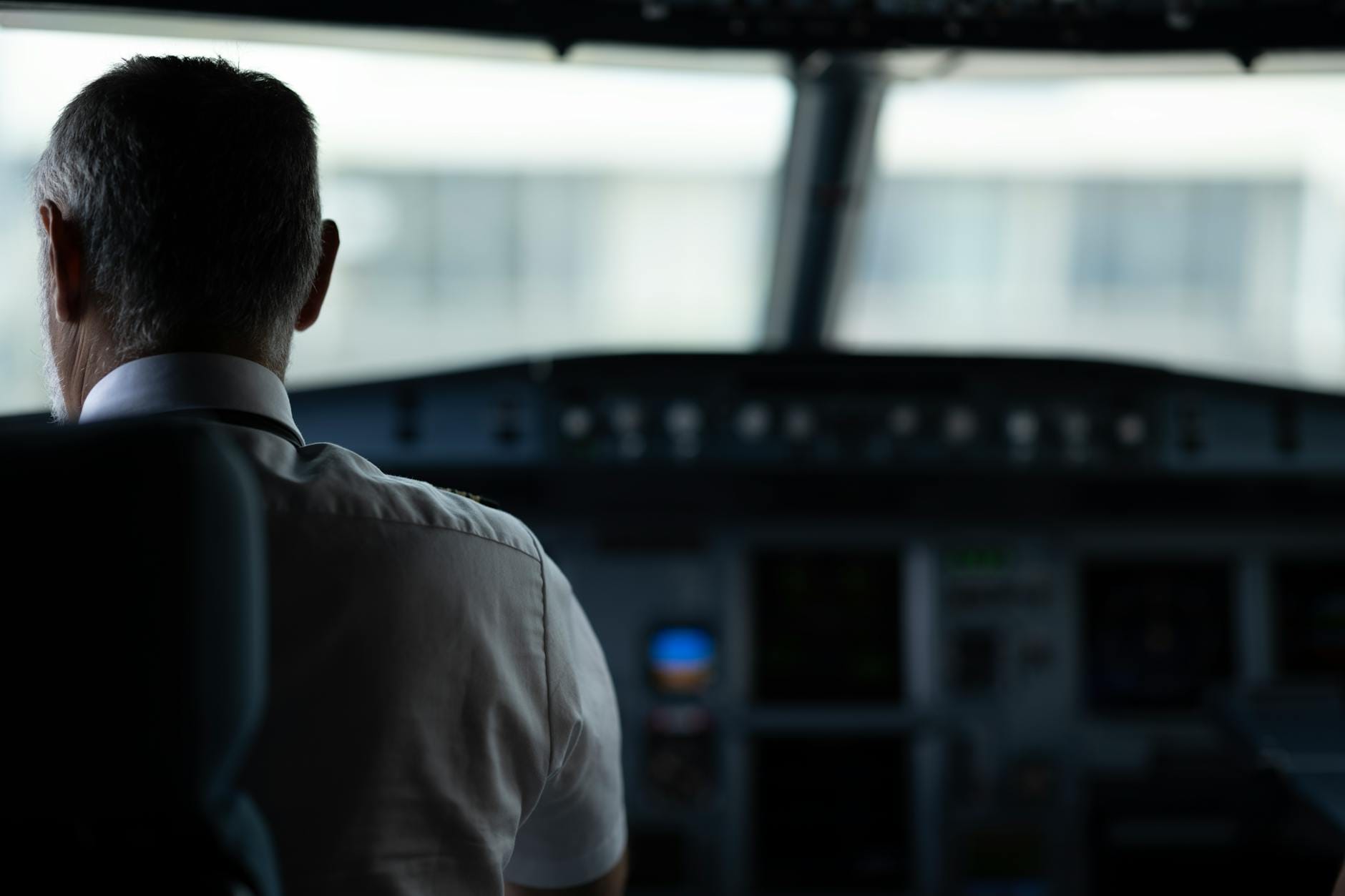 Pilot liniowy w kokpicie samolotu podczas wykonywania obowiązków