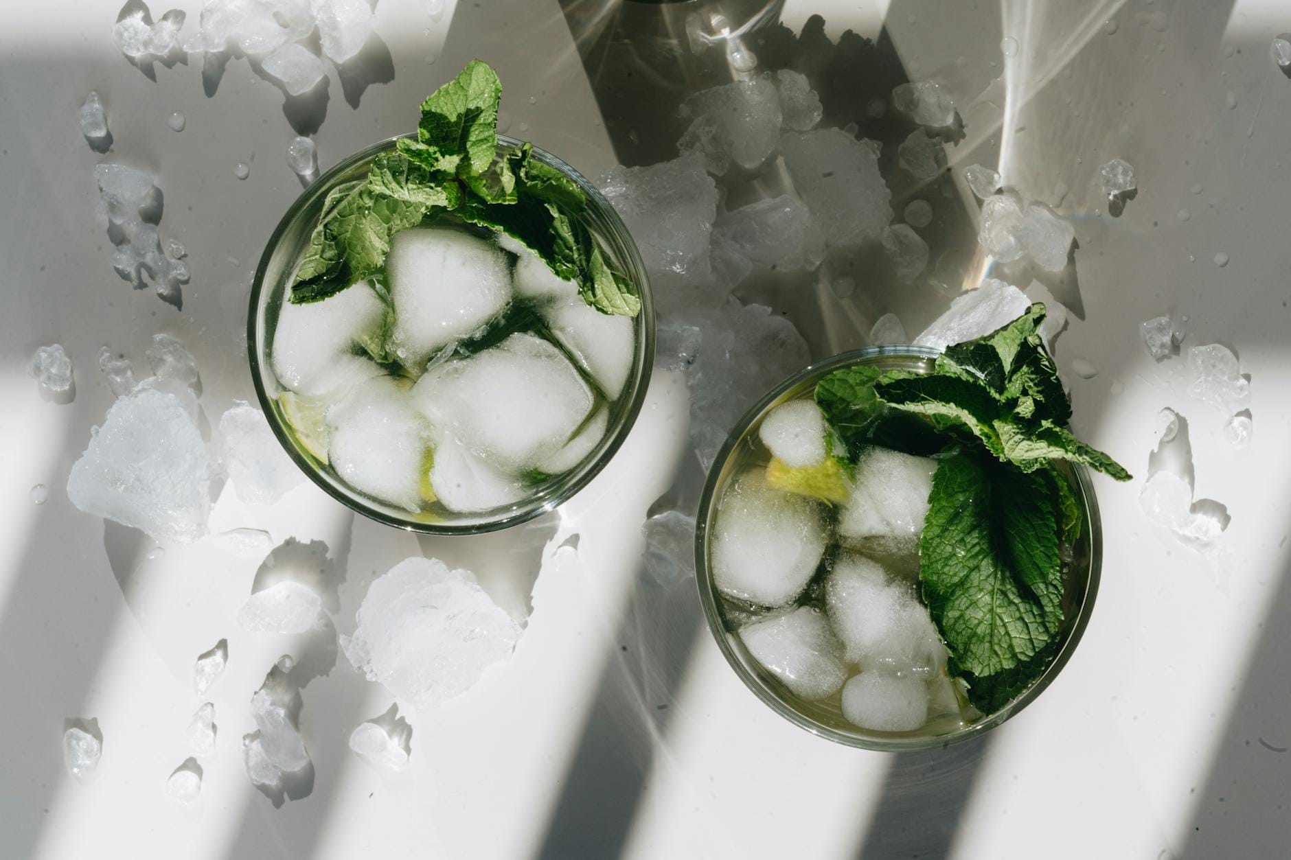 Widok z góry na szklanki mojito z lodem i liśćmi mięty Widok z góry na szklanki mojito z lodem i liśćmi mięty