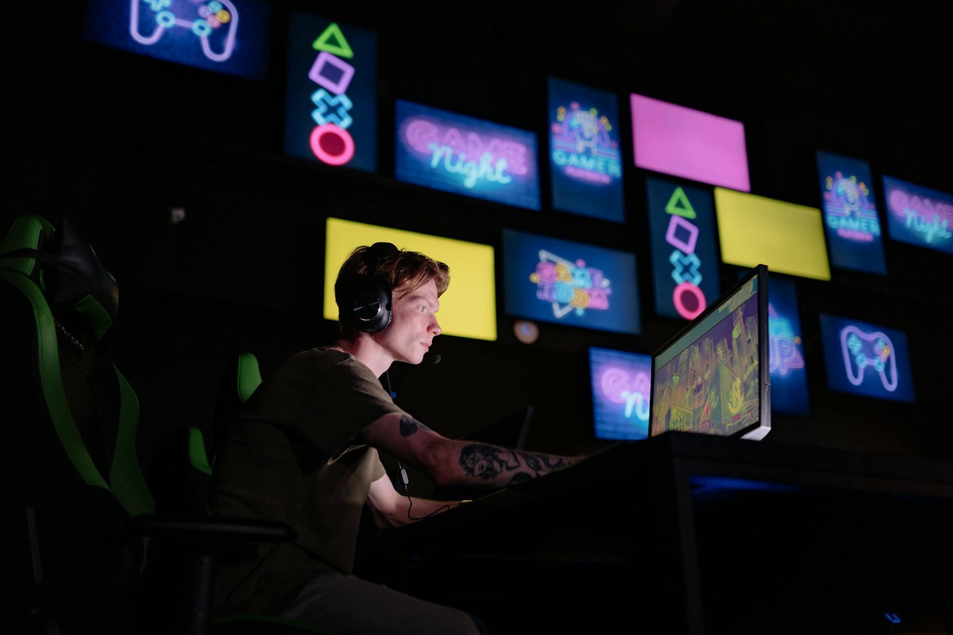 Gracz e-sportowy przy komputerze w neonowo oświetlonym pokoju