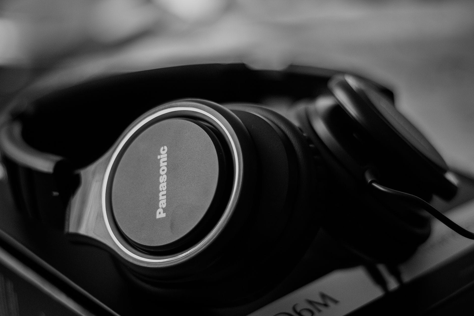 Playlista zamiast kompasu: jak muzyka elektroniczna wyznacza rytm dnia Zbliżenie czarnych słuchawek na tle rozmytego tła w czerni i bieli